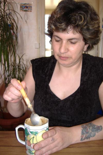 La maîtresse des lieu remuant son café